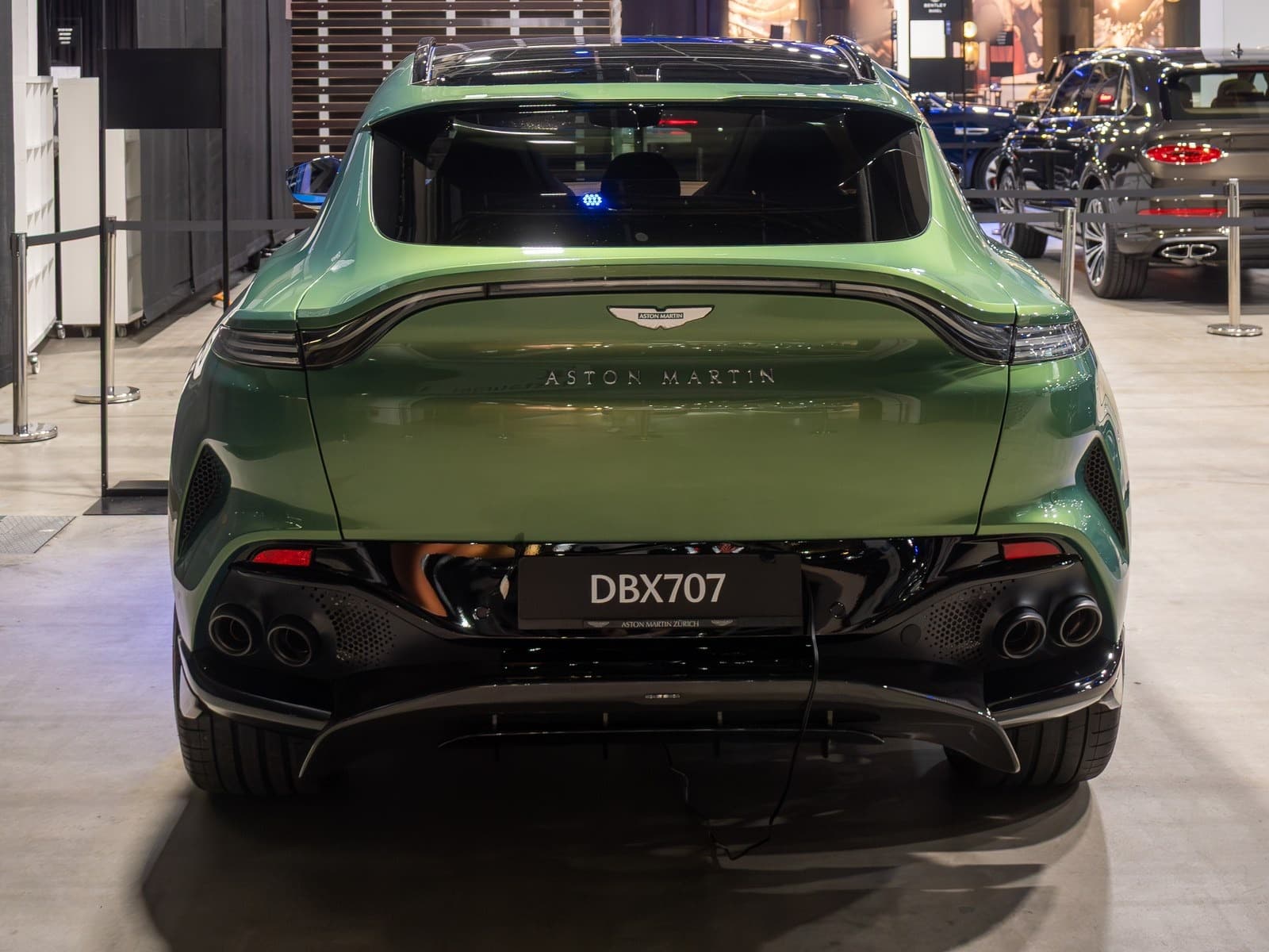 Aston Martin DBX707 verde, vista posteriore a un salone