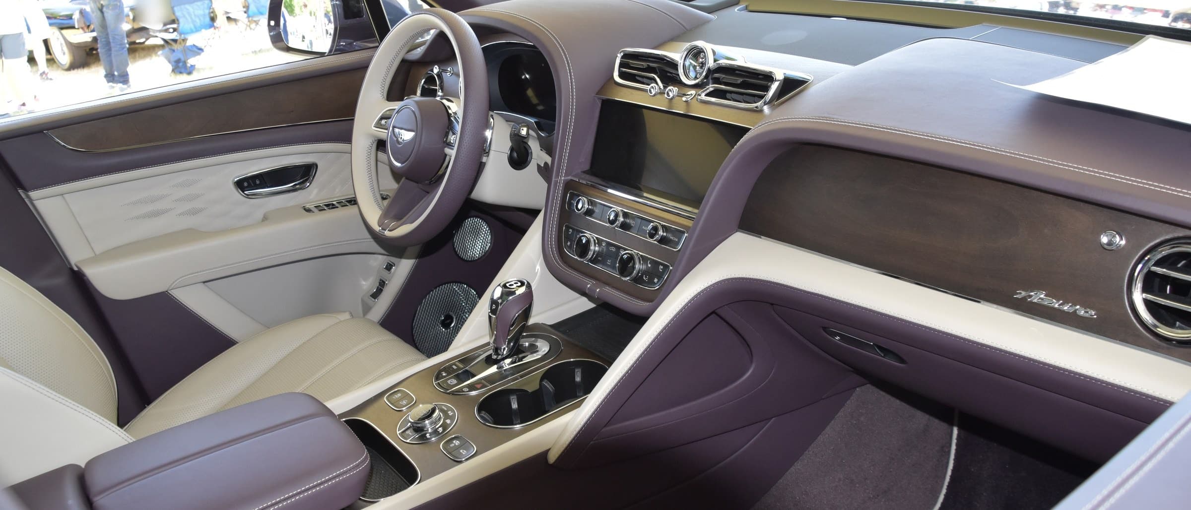 Posto di guida della Bentley Bentayga con volante, schermo centrale, bocchette e cambio cromato
