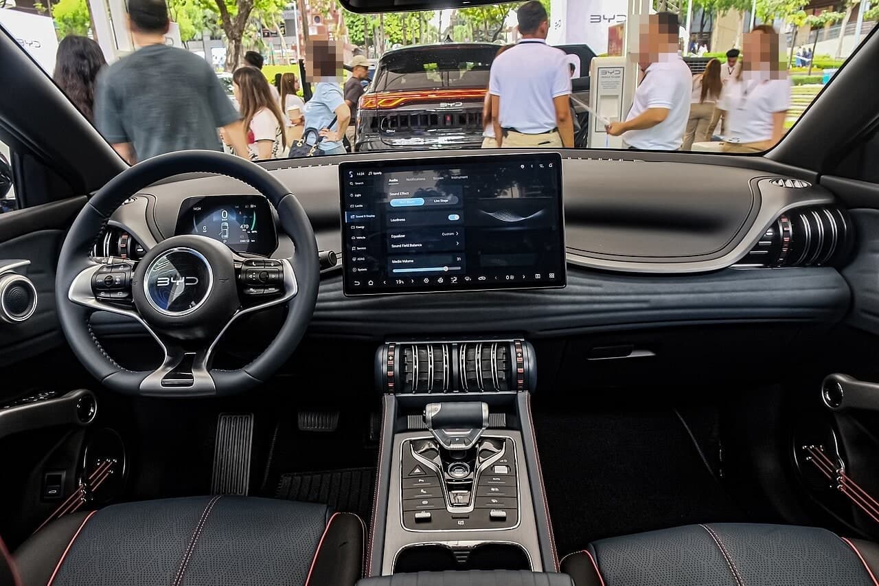 Abitacolo della BYD Atto 3 Premium: plancia con schermo centrale rotante, quadro strumenti digitale e maniglie delle portiere a corde di chitarra