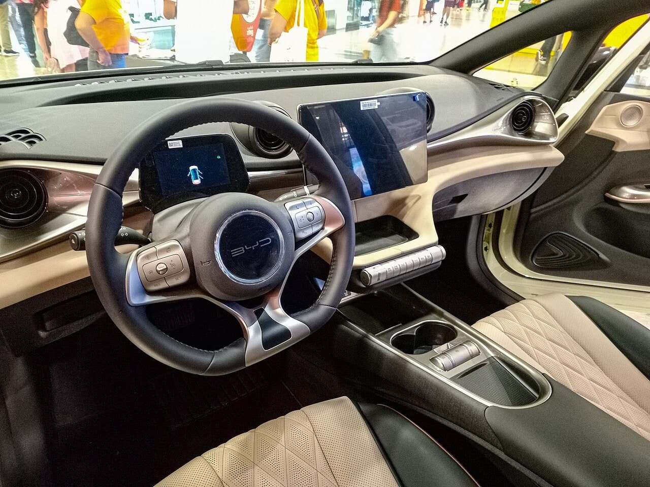 Abitacolo della BYD Dolphin: plancia a manubrio con bocchette circolari, schermo centrale rotante e piccolo quadro strumenti digitale
