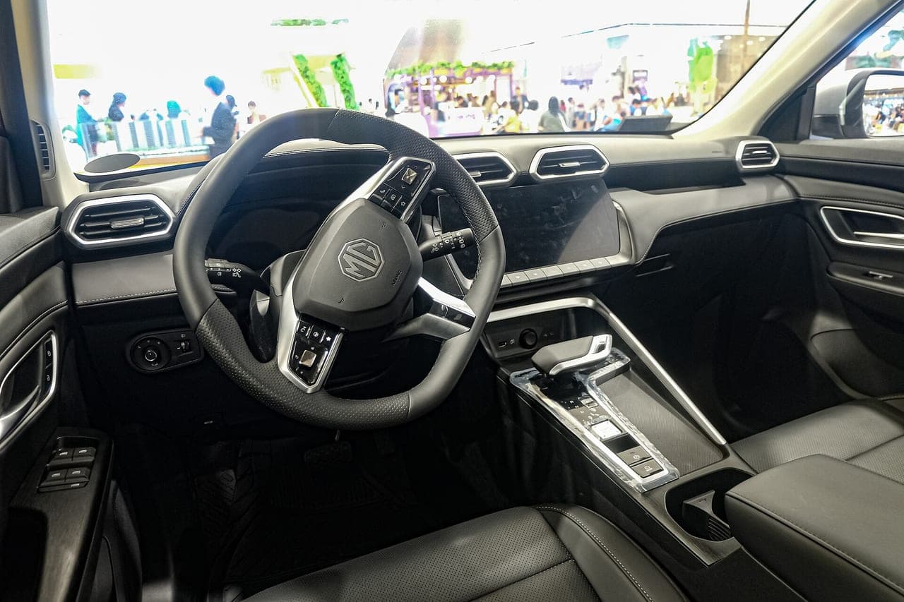 MG ZS Hybrid+ di seconda generazione, abitacolo lato guida con volante, schermo centrale e selettore del cambio automatico
