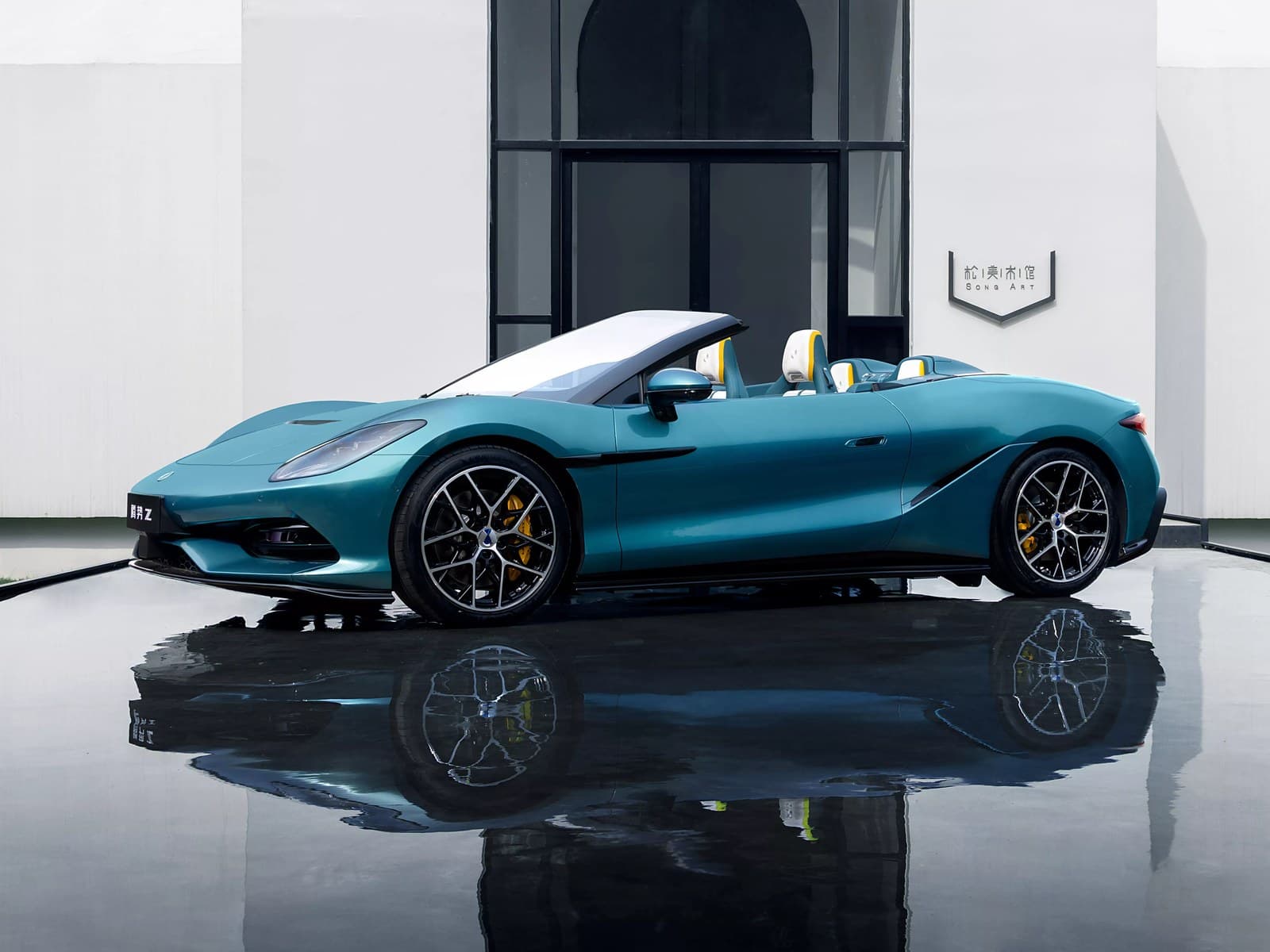Denza Z Spider verde acqua con la capote aperta, vista di lato davanti a un edificio bianco