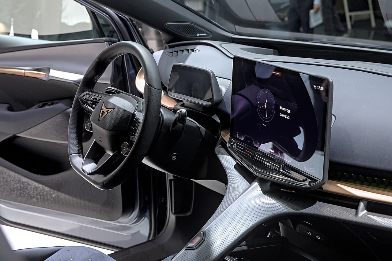 Cupra Tavascan, posto di guida con volante Cupra e grande schermo centrale inclinato