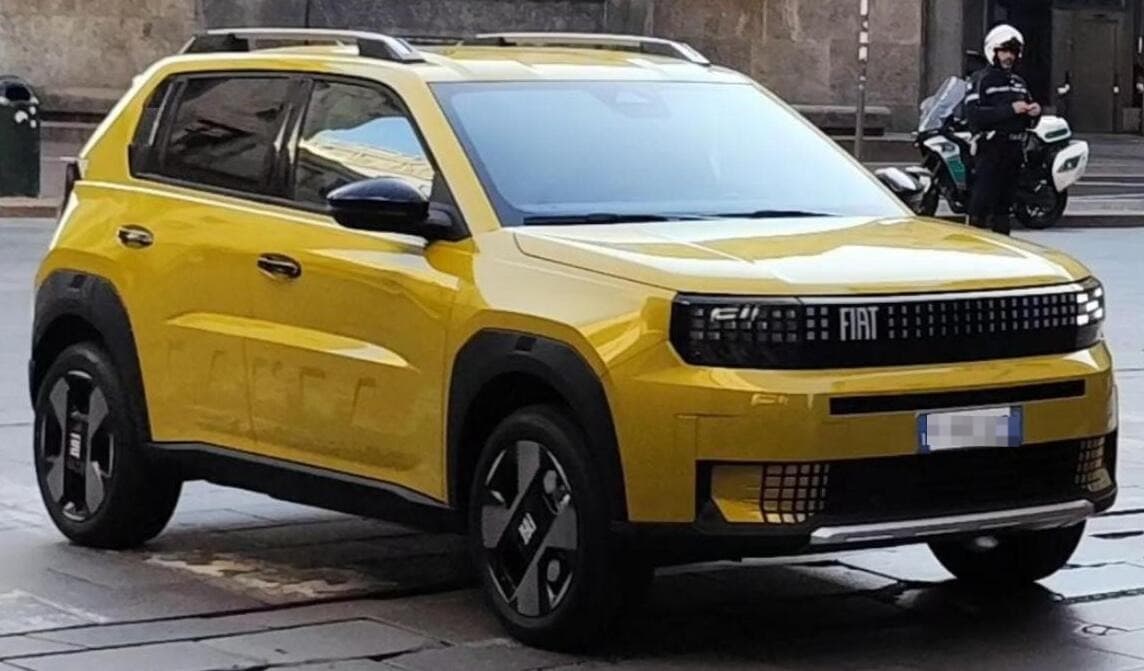 Fiat Grande Panda di colore chiaro vista di tre quarti anteriore, parcheggiata in strada
