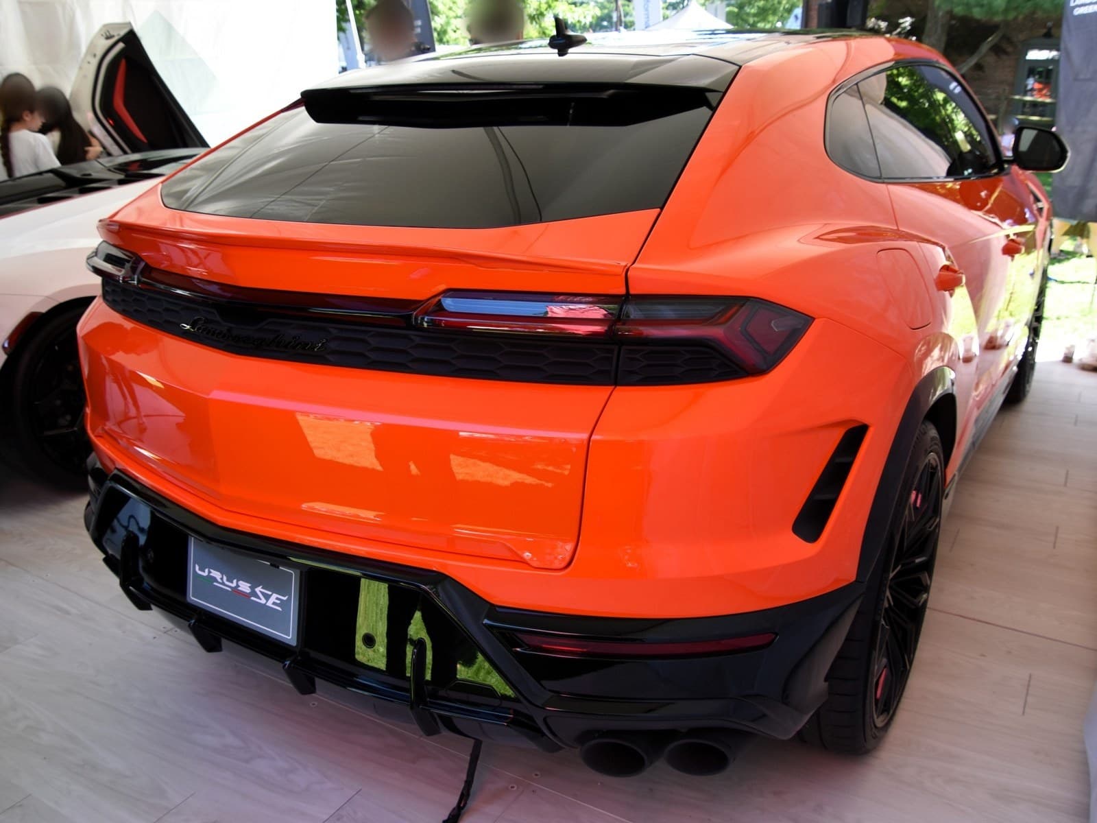 Lamborghini Urus SE arancione, vista posteriore di tre quarti con il cavo di ricarica