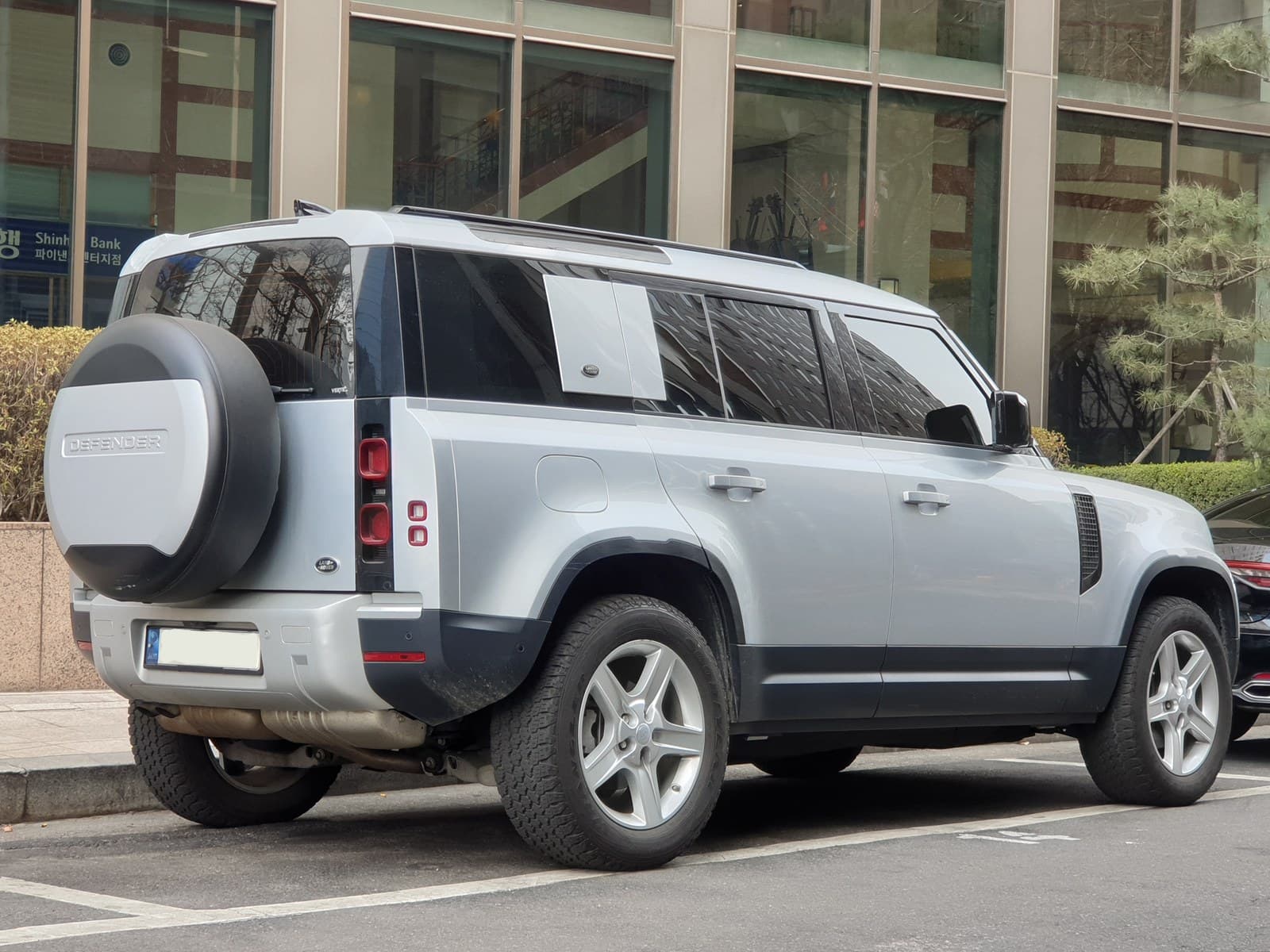 Land Rover Defender 110 argento, vista posteriore di tre quarti