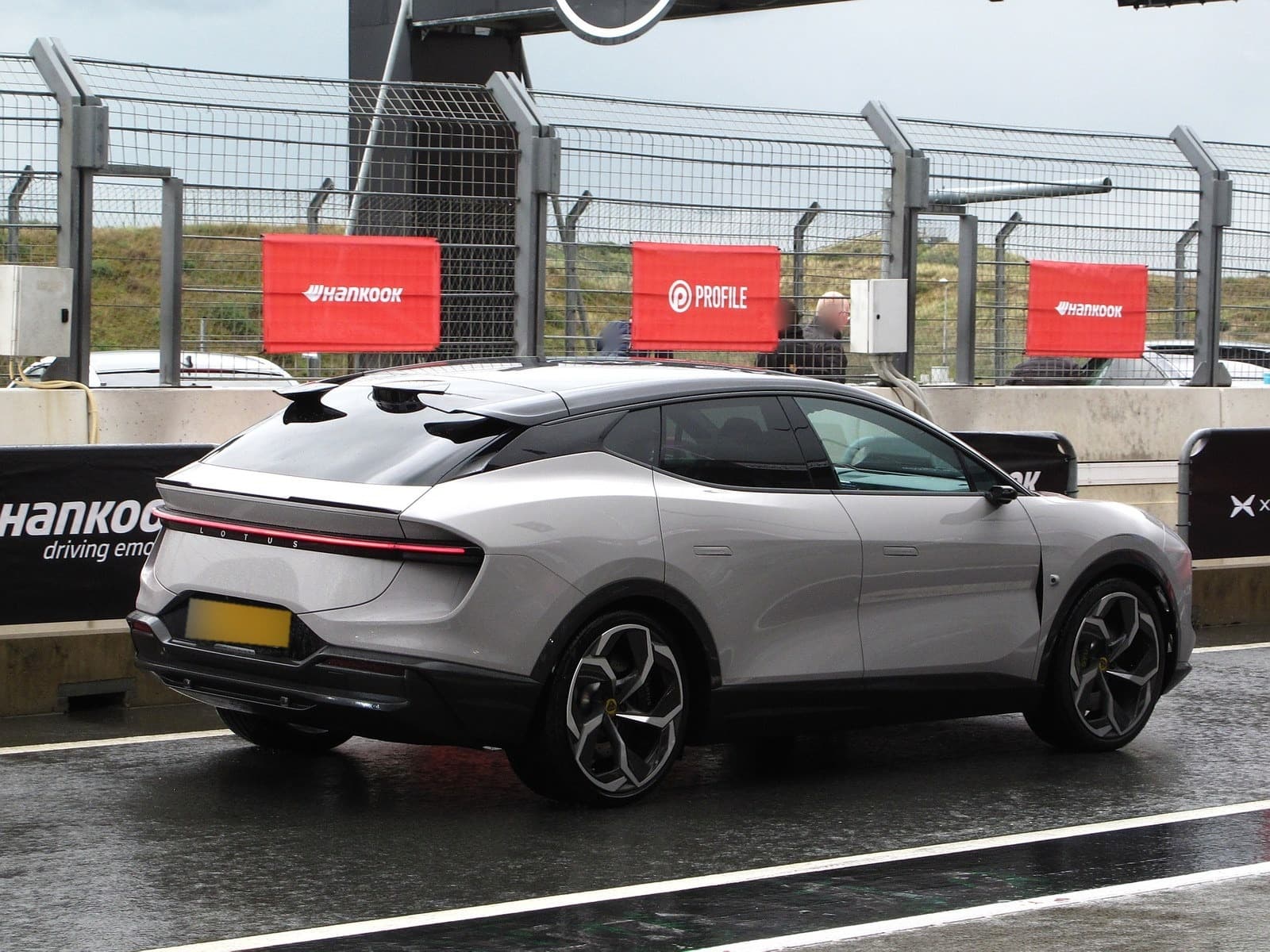 Lotus Eletre grigio chiaro, vista posteriore di tre quarti ai box di un circuito