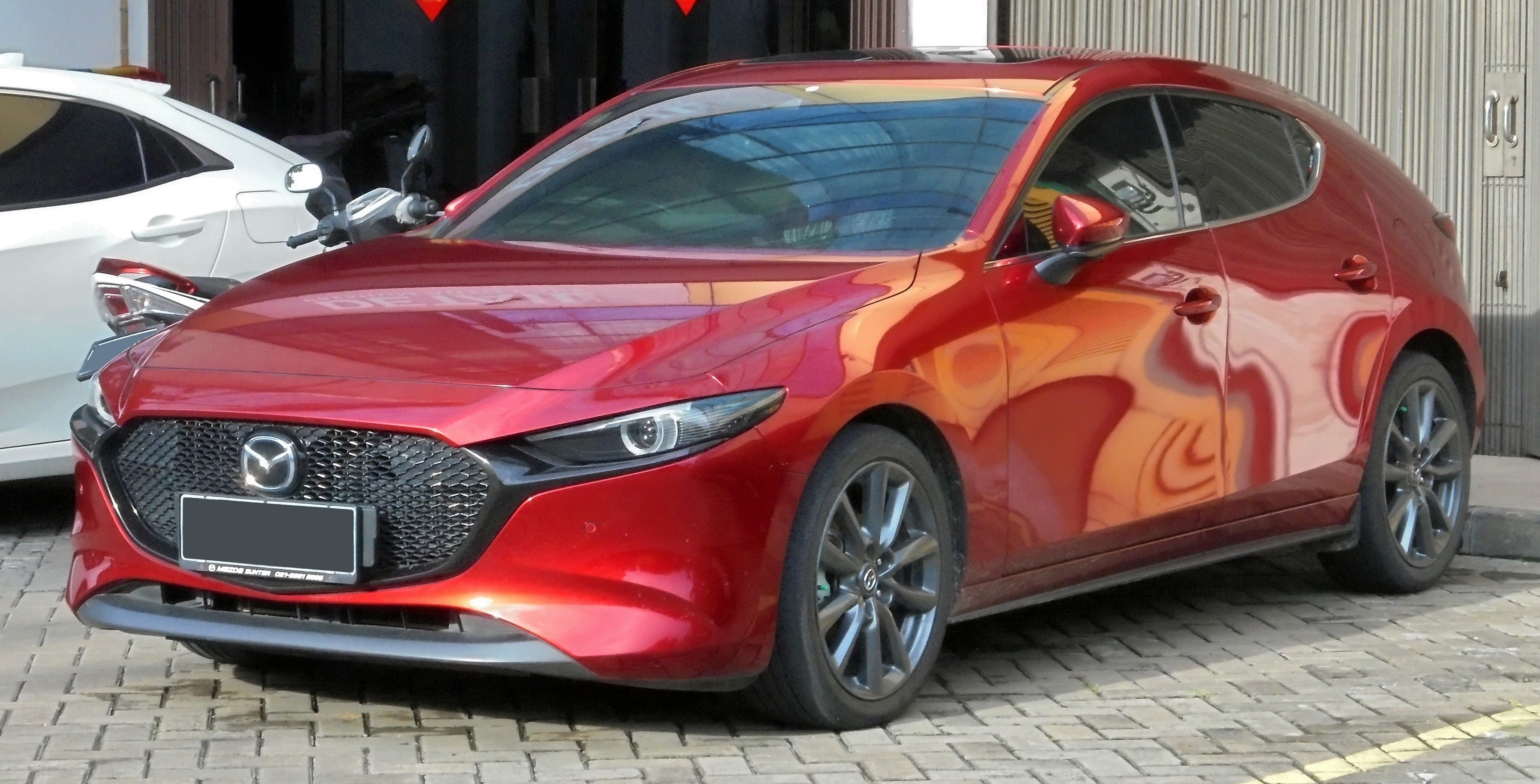 Mazda3 hatchback rossa di quarta generazione (BP), vista di profilo