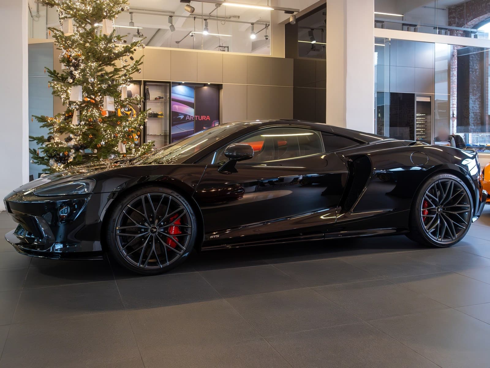 McLaren GTS nera, vista anteriore di tre quarti in un salone