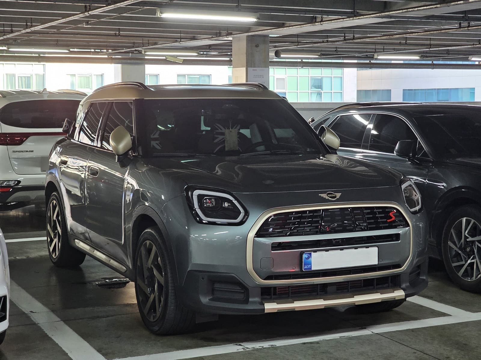Mini Countryman grigio-verde, vista anteriore di tre quarti in un parcheggio coperto