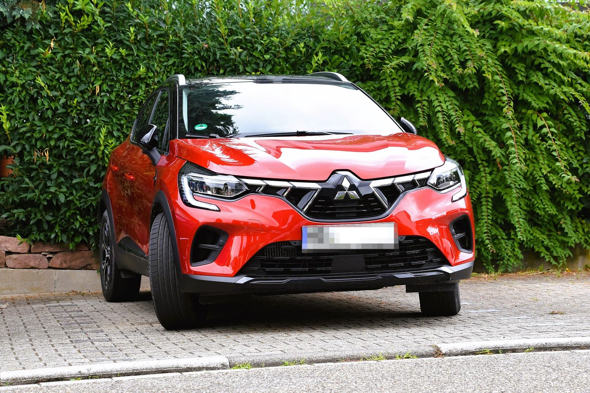 Mitsubishi ASX HEV di seconda generazione (2023) di colore rosso, vista di tre quarti anteriore
