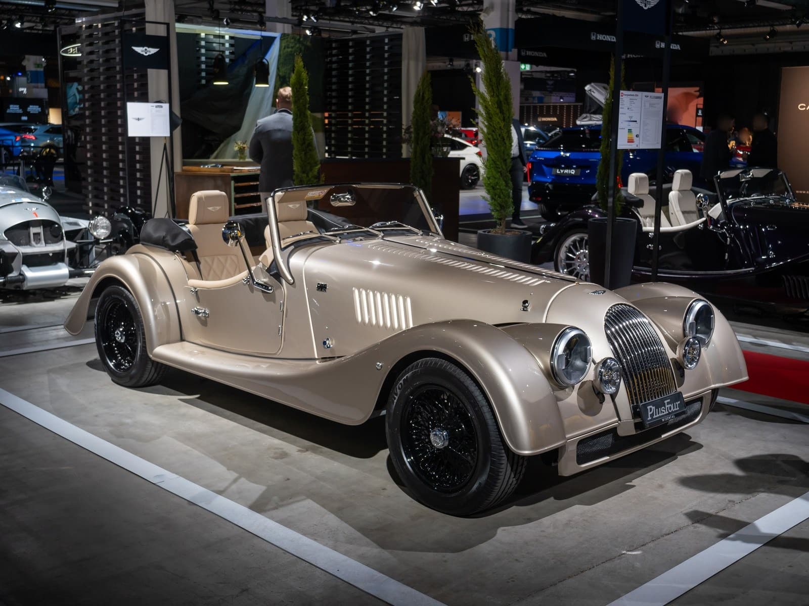 Morgan Plus Four color champagne, vista anteriore di tre quarti a un salone