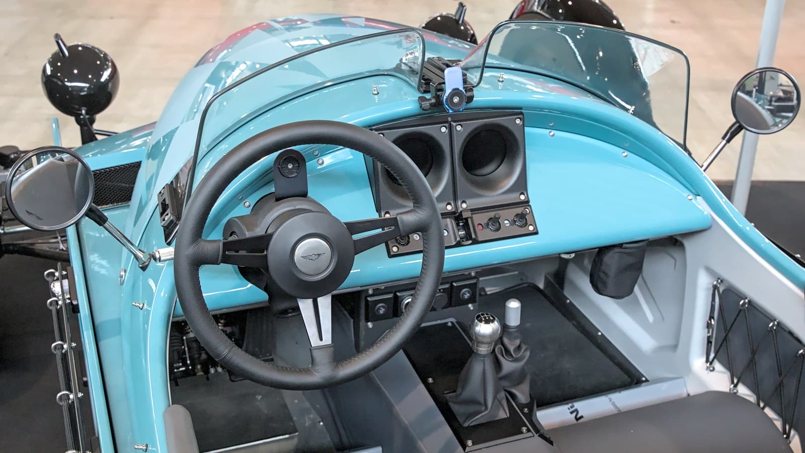 Morgan Super 3 azzurra, abitacolo con volante e leva del cambio