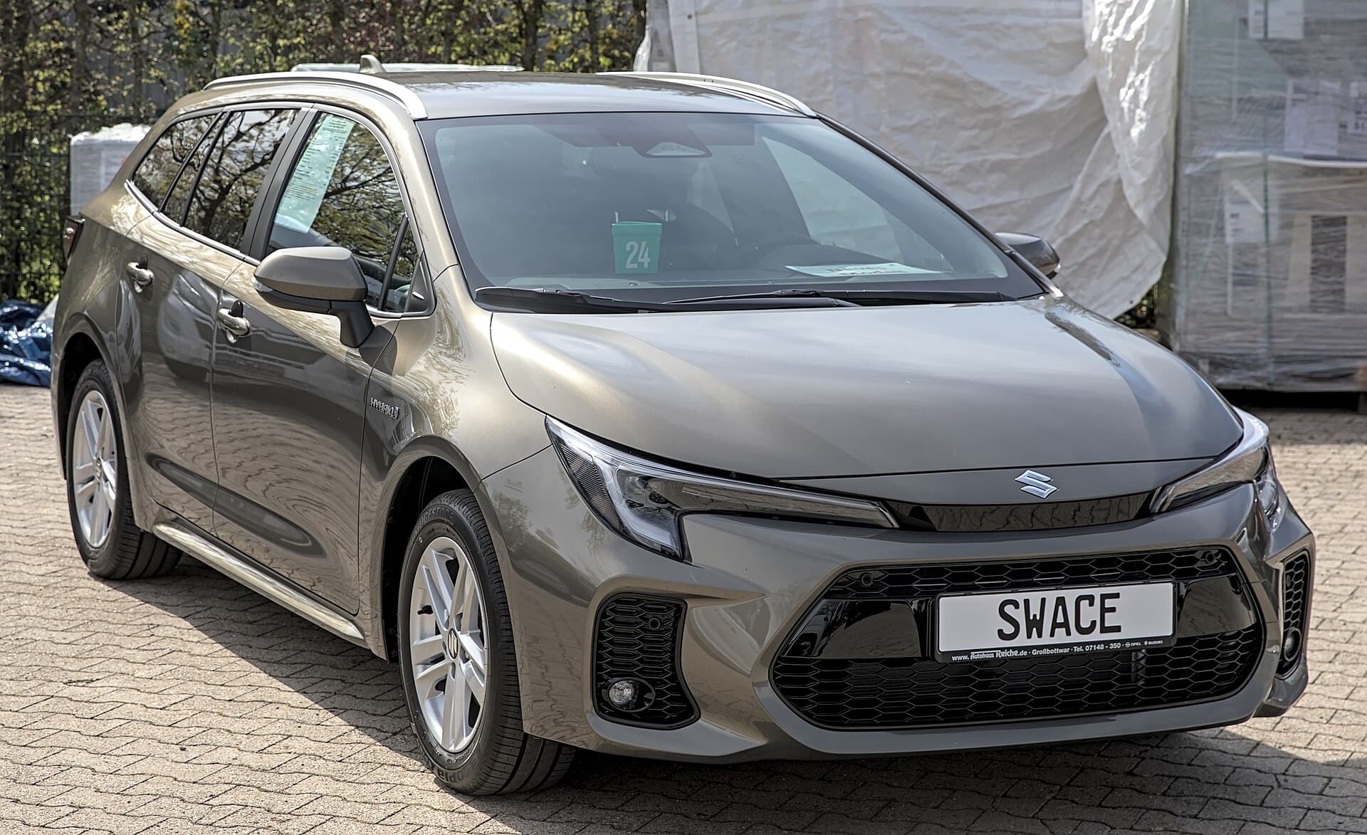 Suzuki Swace (restyling) station wagon grigia esposta a una fiera dell'auto in Germania nel 2023