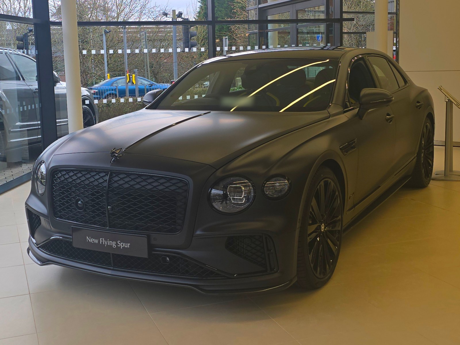Bentley Flying Spur grigio opaco, vista anteriore di tre quarti in una concessionaria