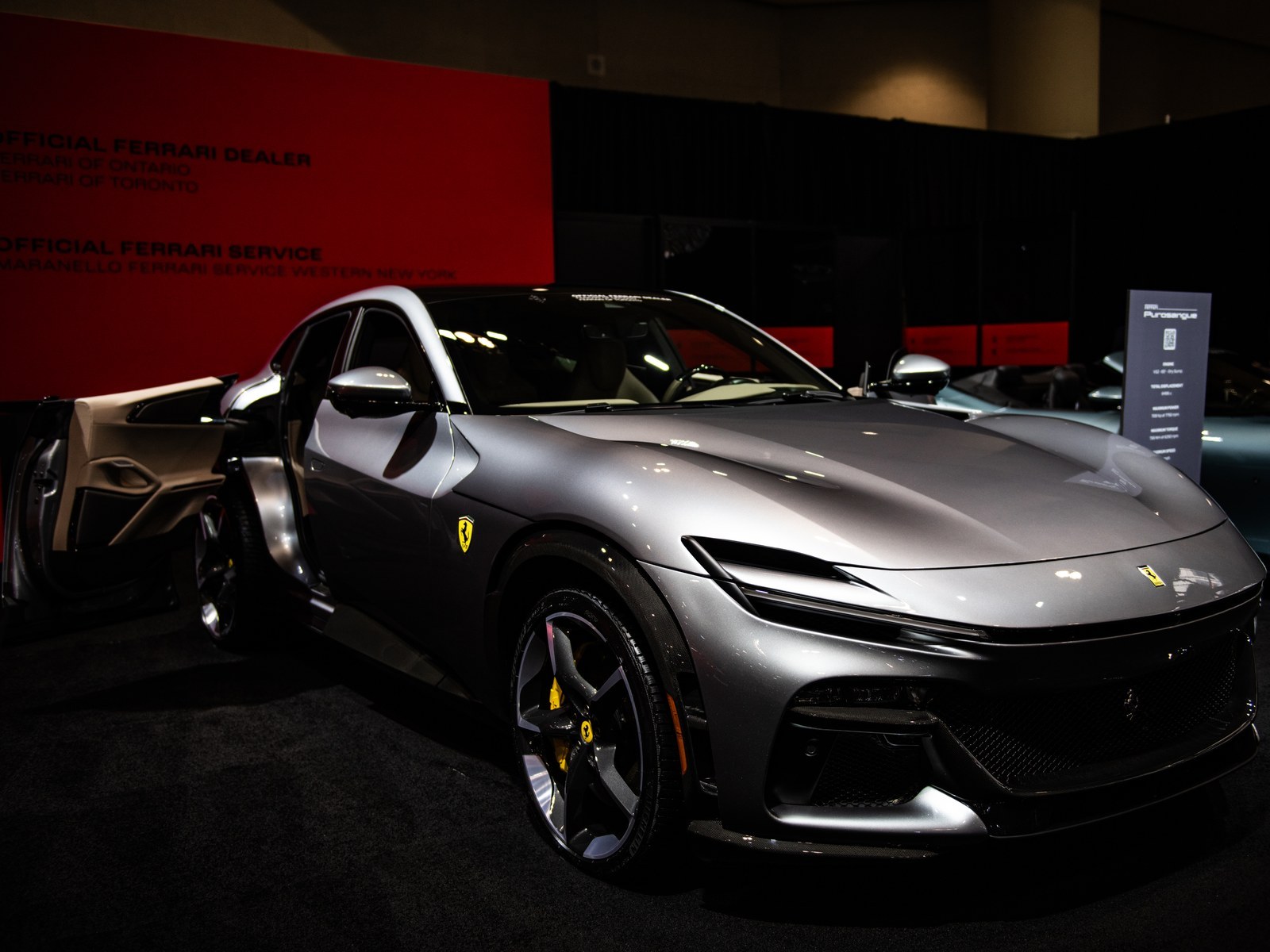 Ferrari Purosangue grigia, vista anteriore di tre quarti con la porta posteriore aperta