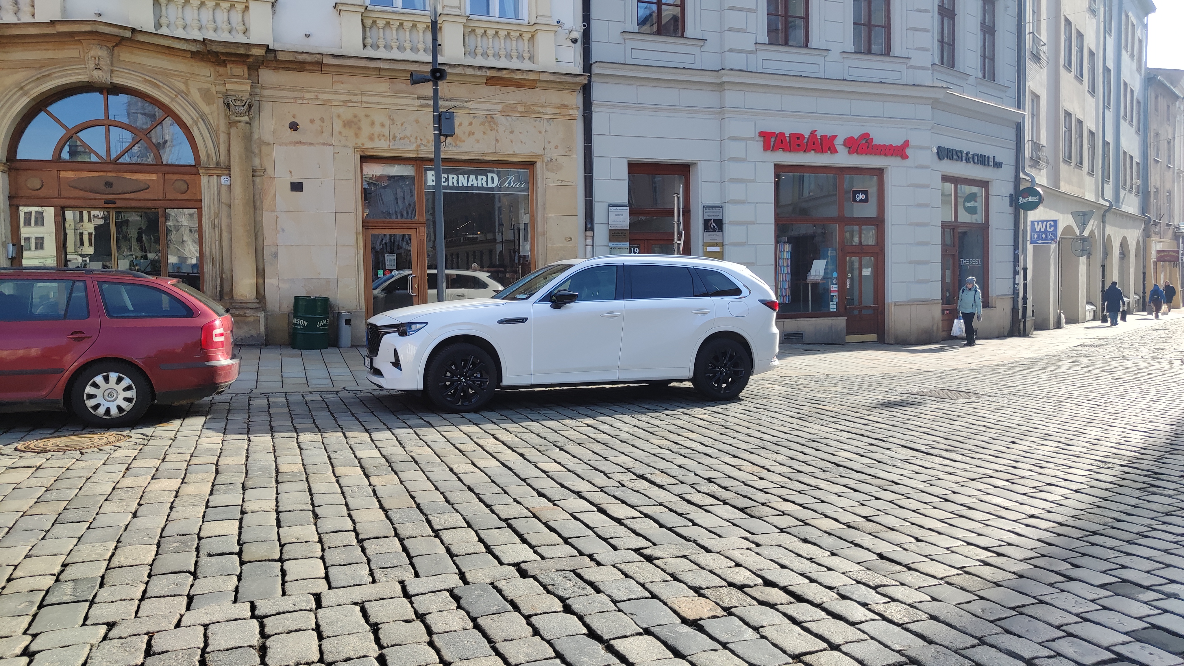 Mazda CX-80 bianca vista di tre quarti anteriore parcheggiata in piazza