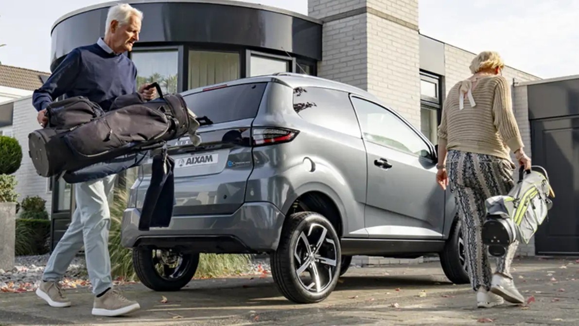 Aixam e-Crossover Premium grigia, vista posteriore di tre quarti davanti a una casa