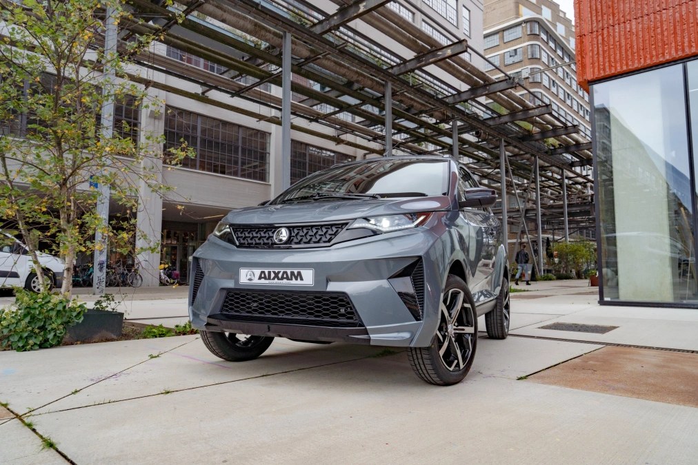 Aixam e-Crossover Premium grigia, vista di tre quarti anteriore in contesto urbano