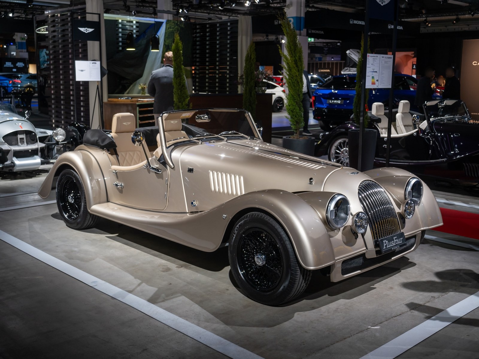 Morgan Plus Four color champagne, vista anteriore di tre quarti a un salone