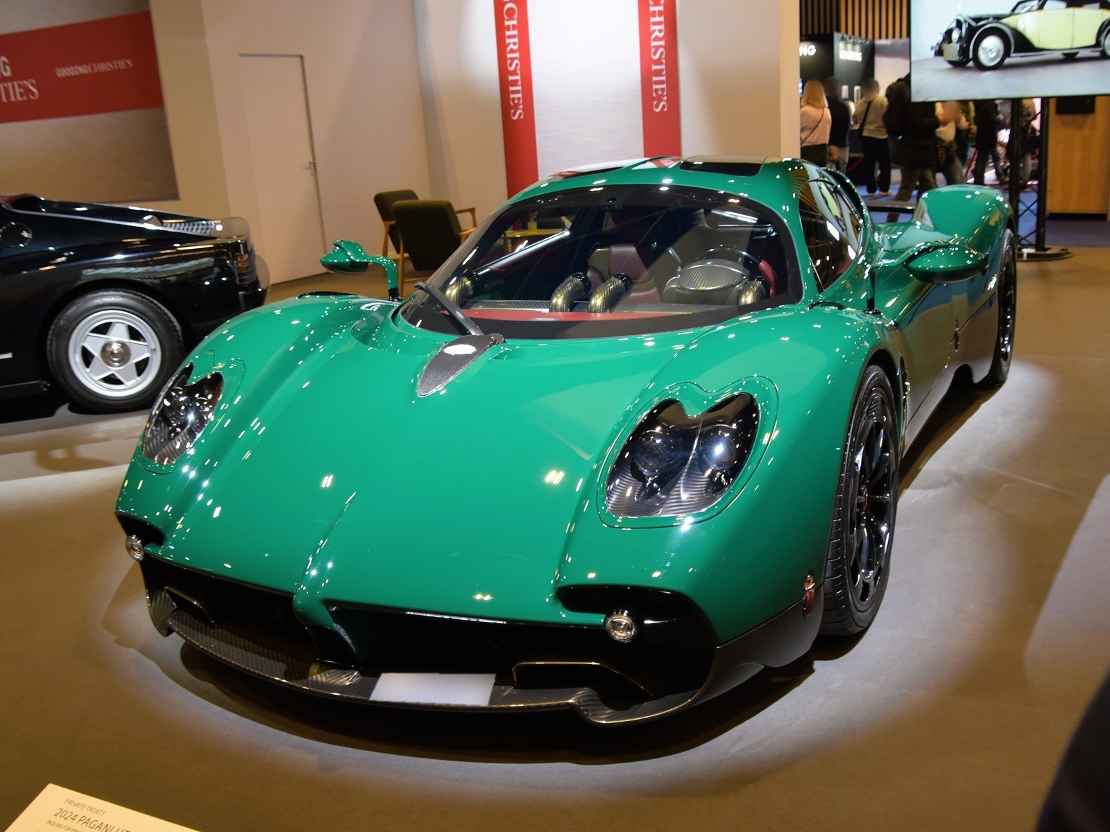 Pagani Utopia verde, vista anteriore di tre quarti su una pedana espositiva