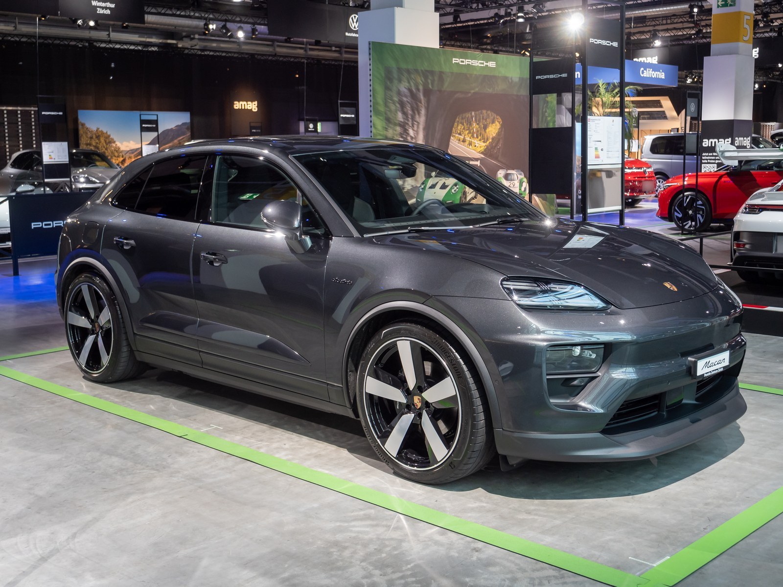 Porsche Macan elettrica grigio scuro, vista anteriore di tre quarti al salone di Zurigo