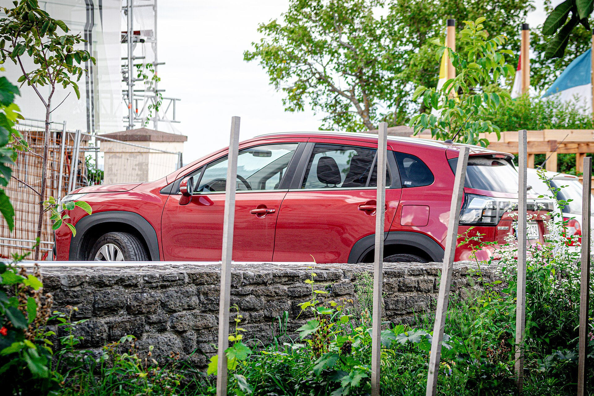 Suzuki S-Cross di colore rosso parcheggiata, vista di tre quarti anteriore