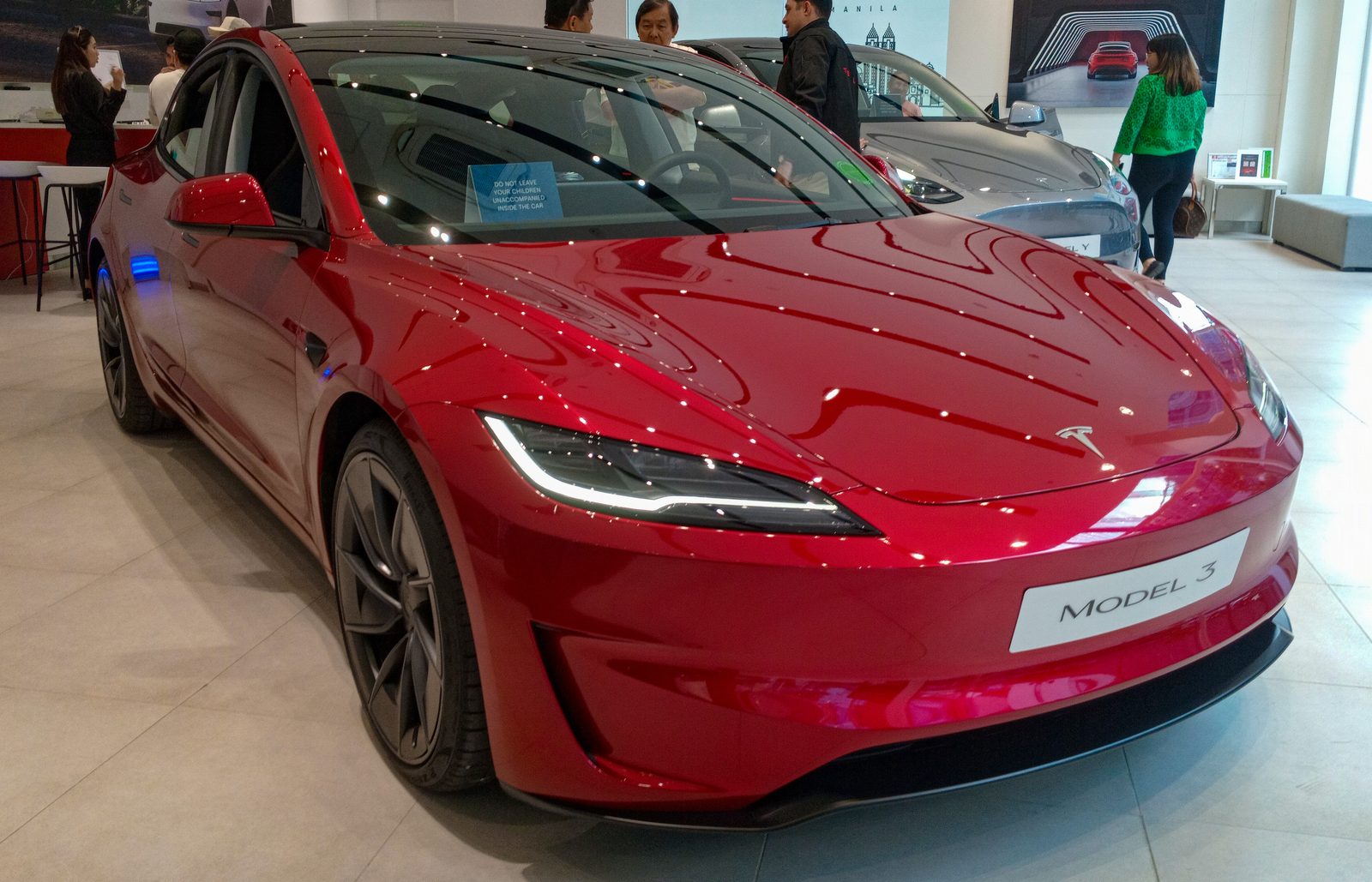 Tesla Model 3 Performance (restyling) in colore Ultra Red, vista anteriore di tre quarti