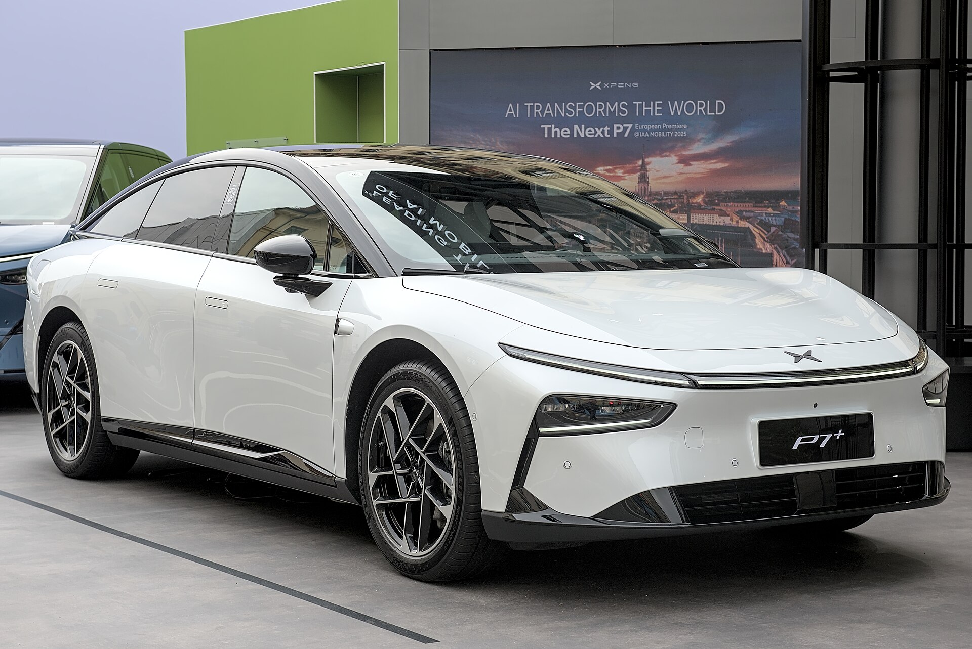 XPeng P7+ bianca vista di tre quarti anteriore, esposta a una fiera dell'auto